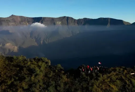 Pendaki menikmati matahari terbit di atas puncak Gunung Tambora